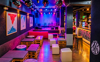 Nightclub interior with colorful lights, stage, and seating in Tangier.