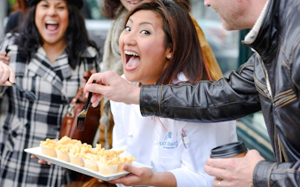 Chef leading a food tasting tour at Pike Place Market, Seattle, with participants sampling pasta.