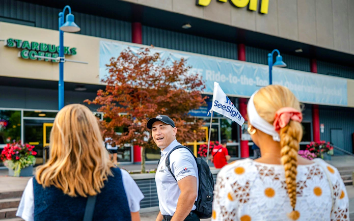 Tour guide leading a group on the Niagara Falls Tour with Journey Behind the Falls and Boat Cruise, Canada.