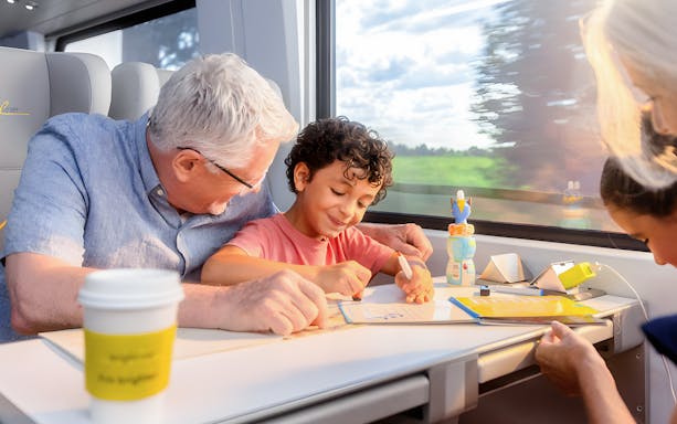 Family enjoying activities on Brightline Train journey.