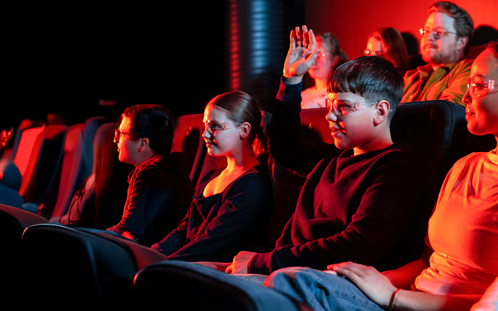 Guests watching the Lava show in Reykjavik theater, one raising hand.