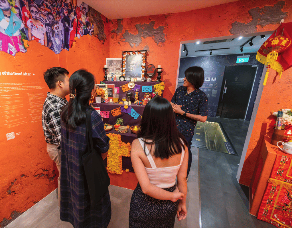 Visitors explore Day of the Dead altar exhibit at Singapore's Hell's Museum.