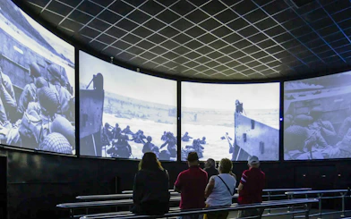 Visitors watching D-Day footage inside Arromanches 360 Circular Cinema, France.