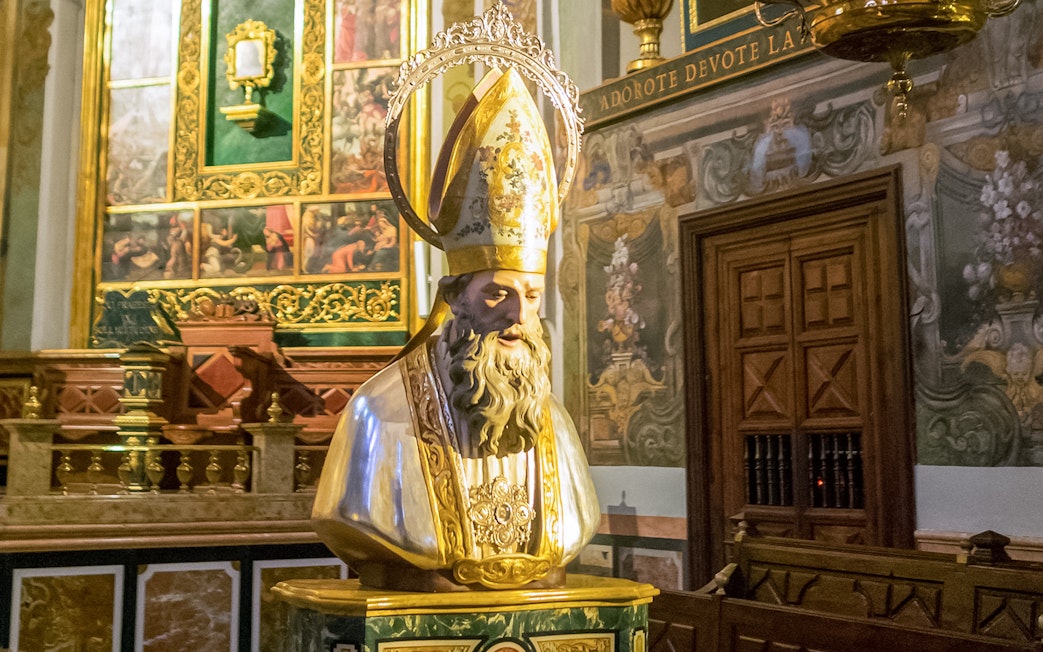 San Nicolas head sculpt inside San Nicolas Church, ornate background.