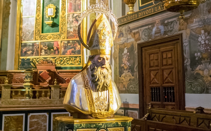 San Nicolas head sculpt inside San Nicolas Church, ornate background.