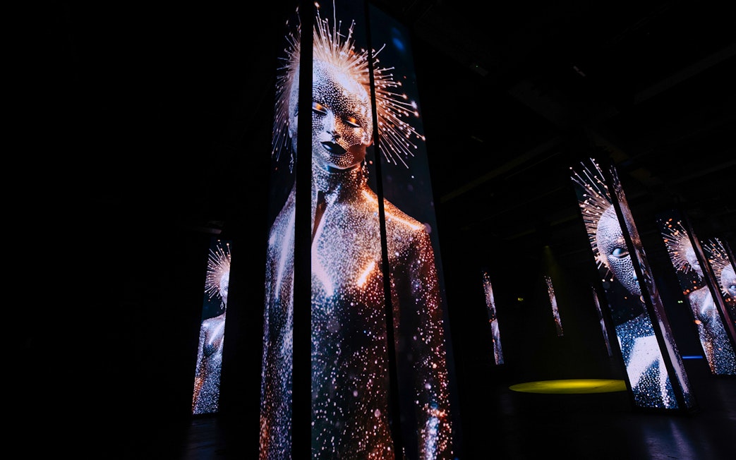 Digital art installation with illuminated figures at Amaze Amsterdam.