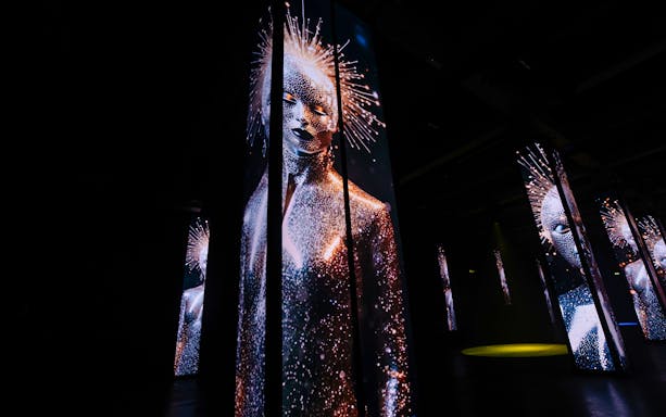Digital art installation with illuminated figures at Amaze Amsterdam.