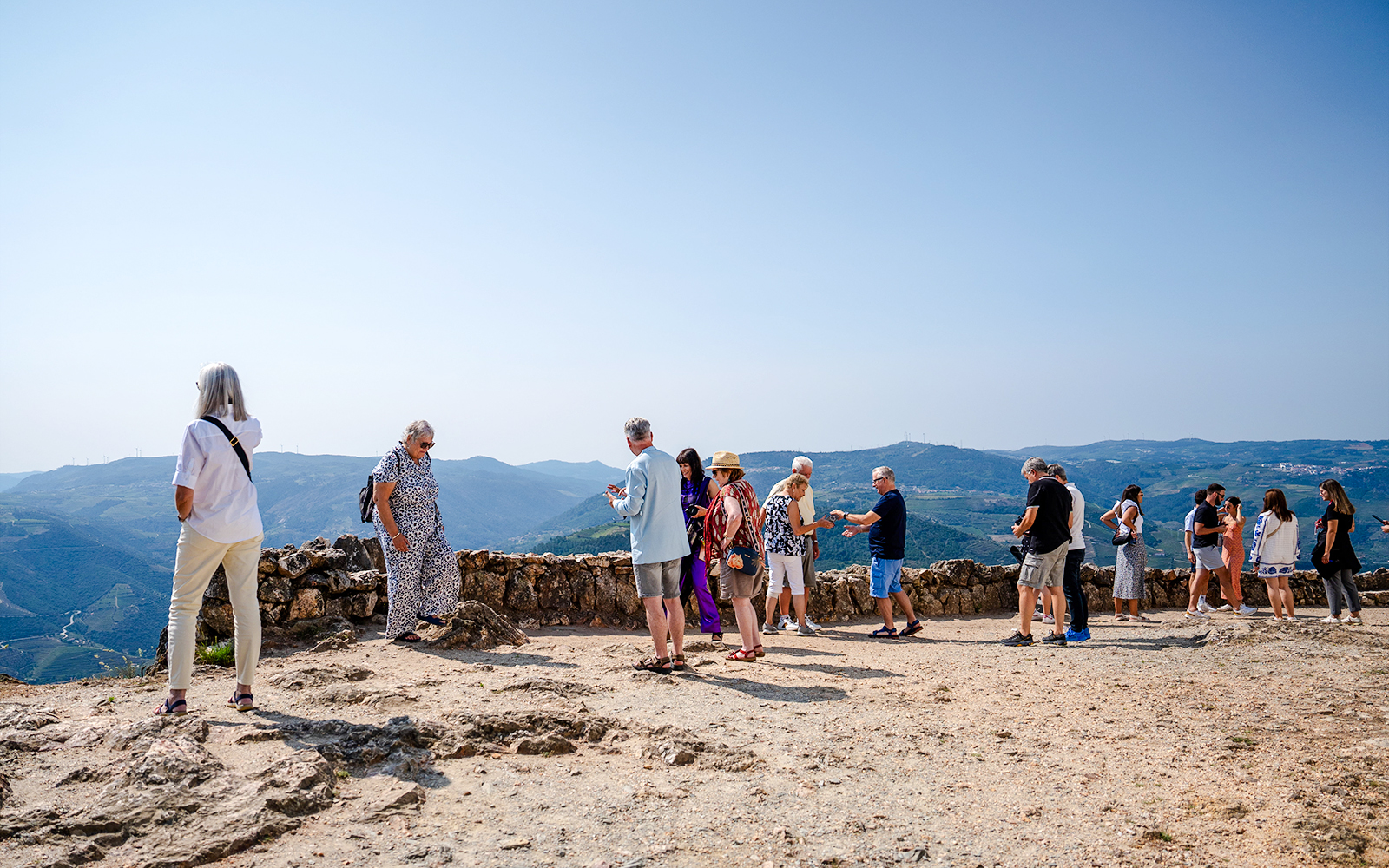 Tourists enjoying panoramic views at a scenic viewpoint in Douro Valley, Portugal.