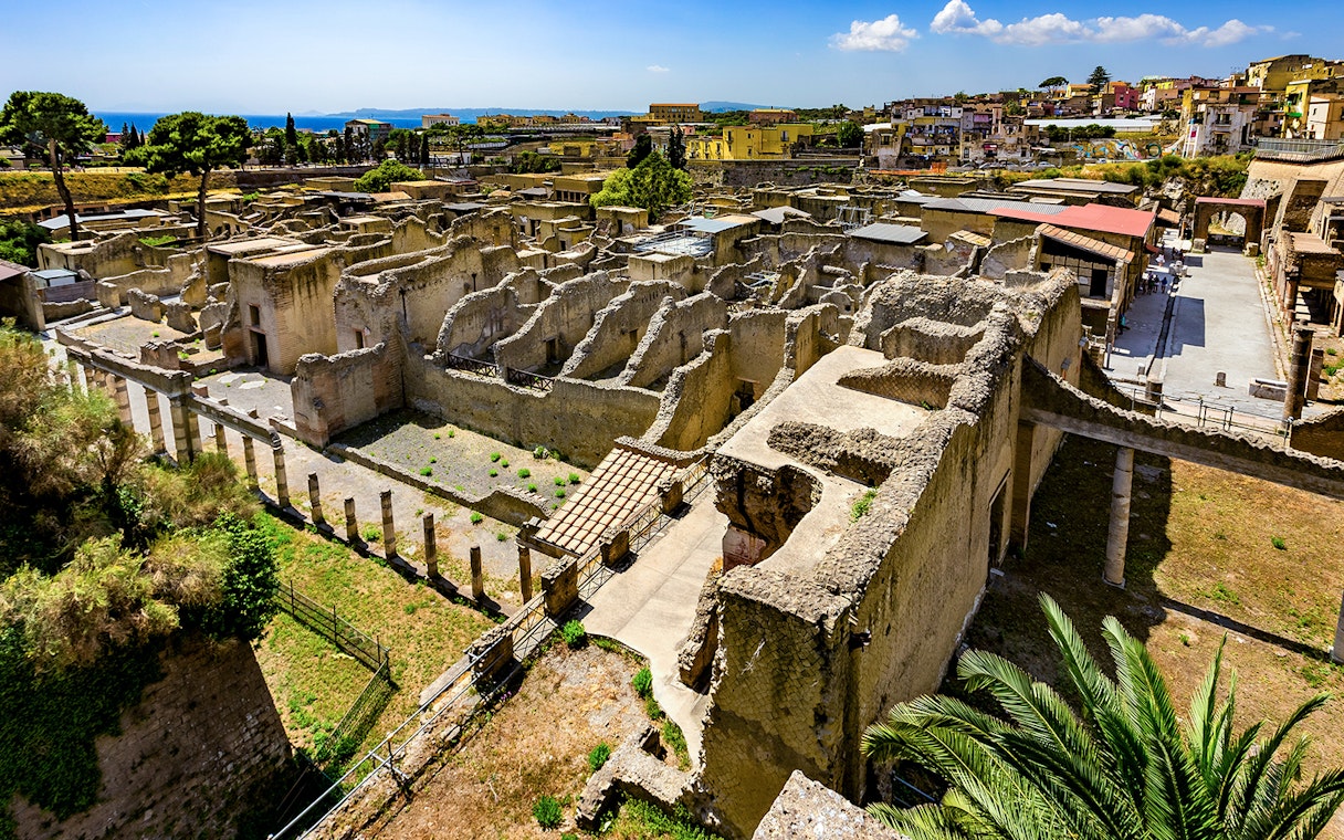Aerial view of ancient ruins in Herculaneum, Italy, with surrounding landscape.
