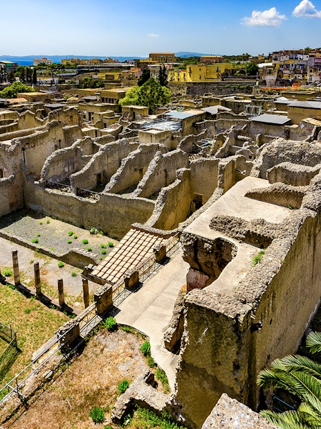 Aerial view of ancient ruins in Herculaneum, Italy, with surrounding landscape.