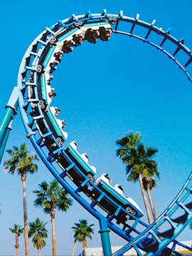 Roller coaster loop at Knott's Berry Farm with palm trees in the background.