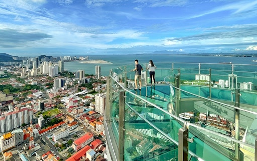 Couple enjoying city and sea view from The Top, Penang observation deck.