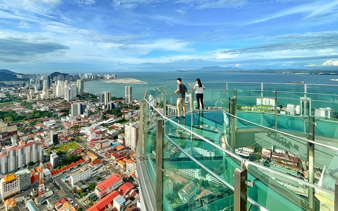 Couple enjoying city and sea view from The Top, Penang observation deck.