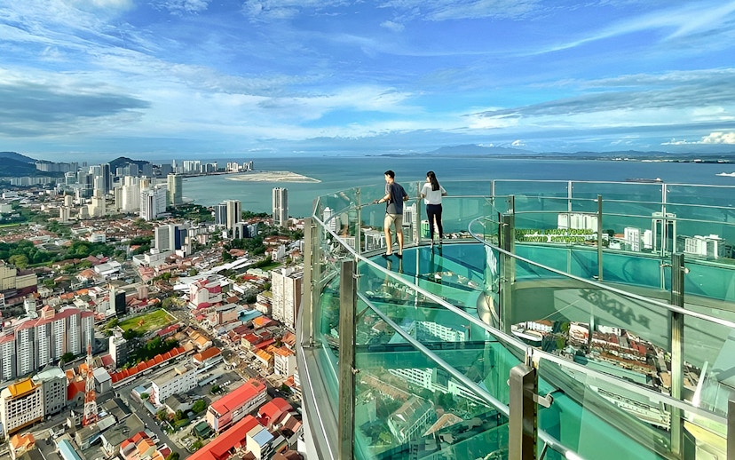 Couple enjoying city and sea view from The Top, Penang observation deck.