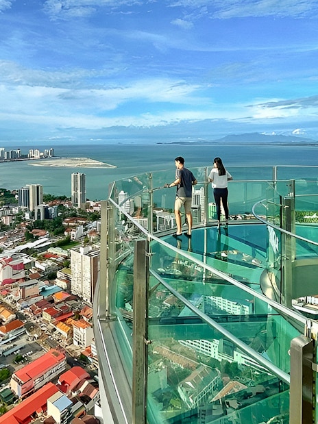 Couple enjoying city and sea view from The Top, Penang observation deck.