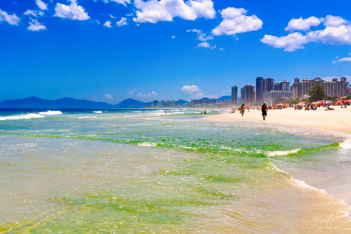 Prainha Beach with city skyline and mountains, Rio de Janeiro.