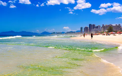 Prainha Beach with city skyline and mountains, Rio de Janeiro.