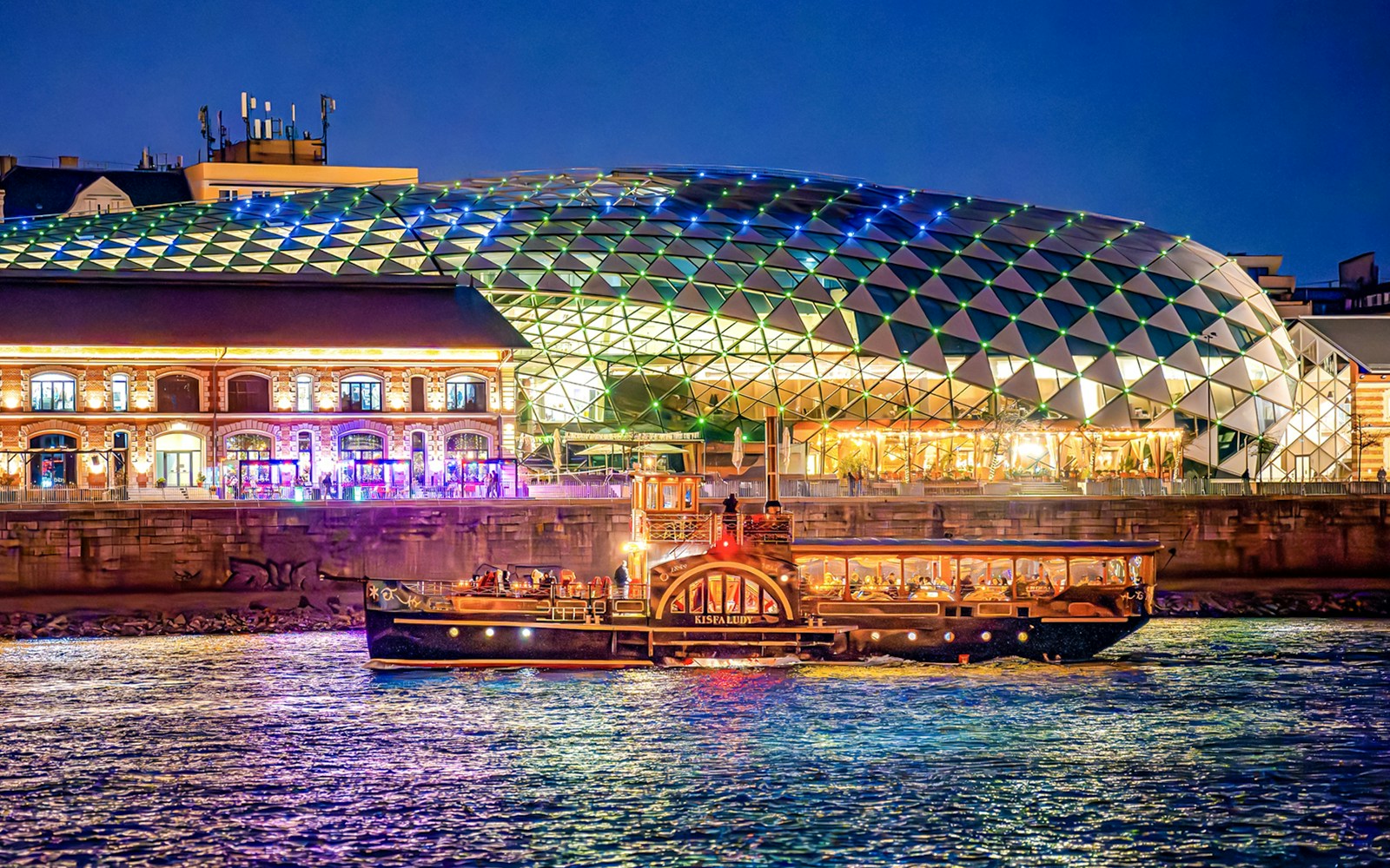 Budapest Danube River nighttime cruise with illuminated cityscape and historic buildings.