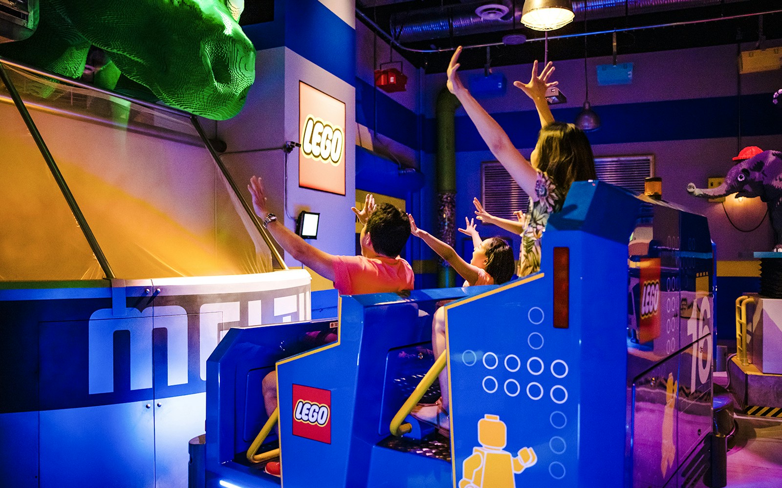 Guests enjoying a ride at Legoland New York with LEGO-themed decor.