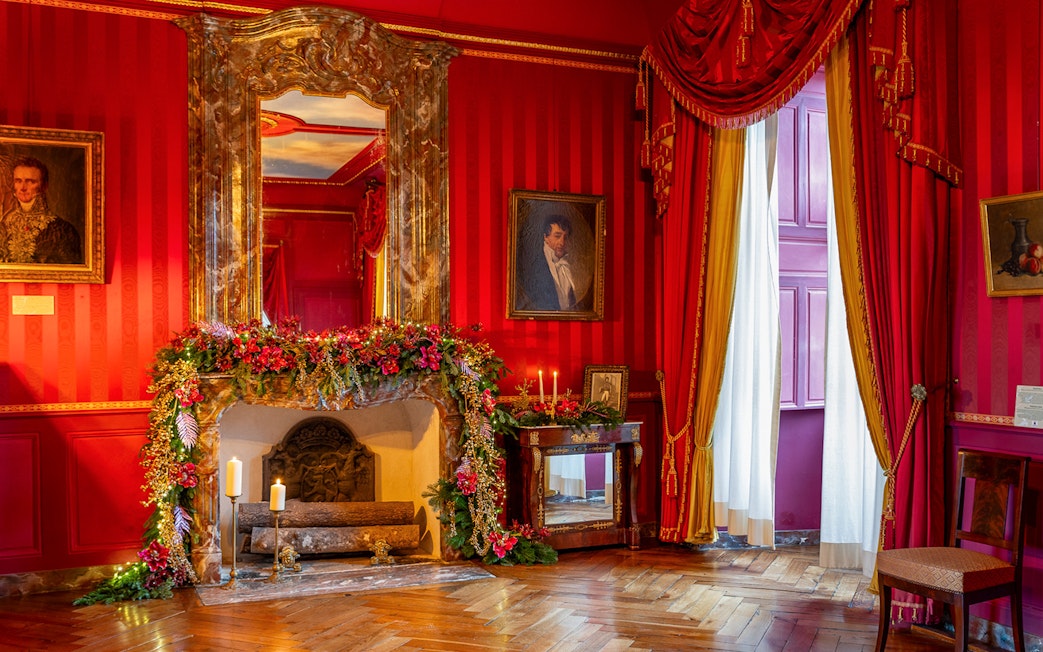 Villandry Castle room with Christmas decorations on fireplace and red drapes.