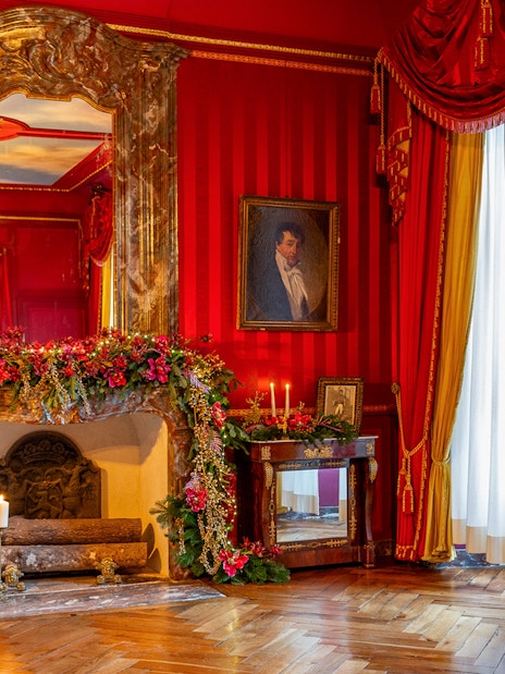 Villandry Castle room with Christmas decorations on fireplace and red drapes.