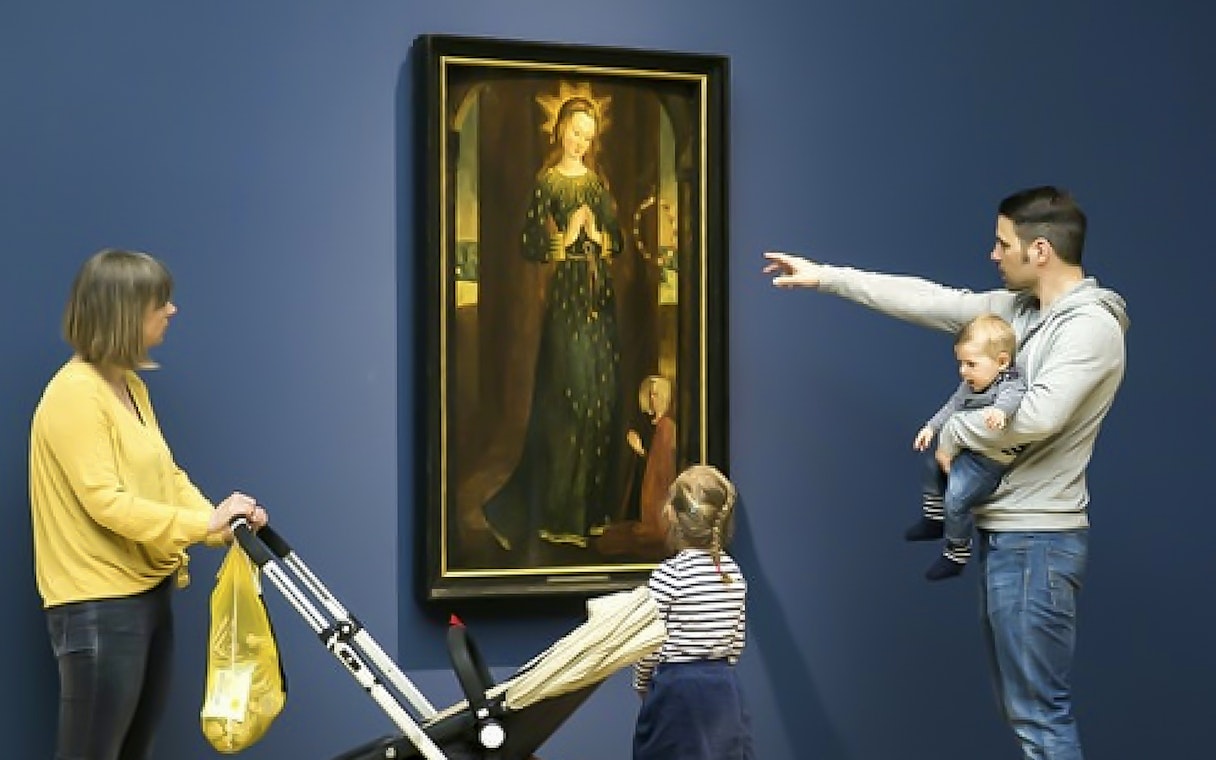 Visitors viewing a religious painting at Hamburger Kunsthalle exhibit.