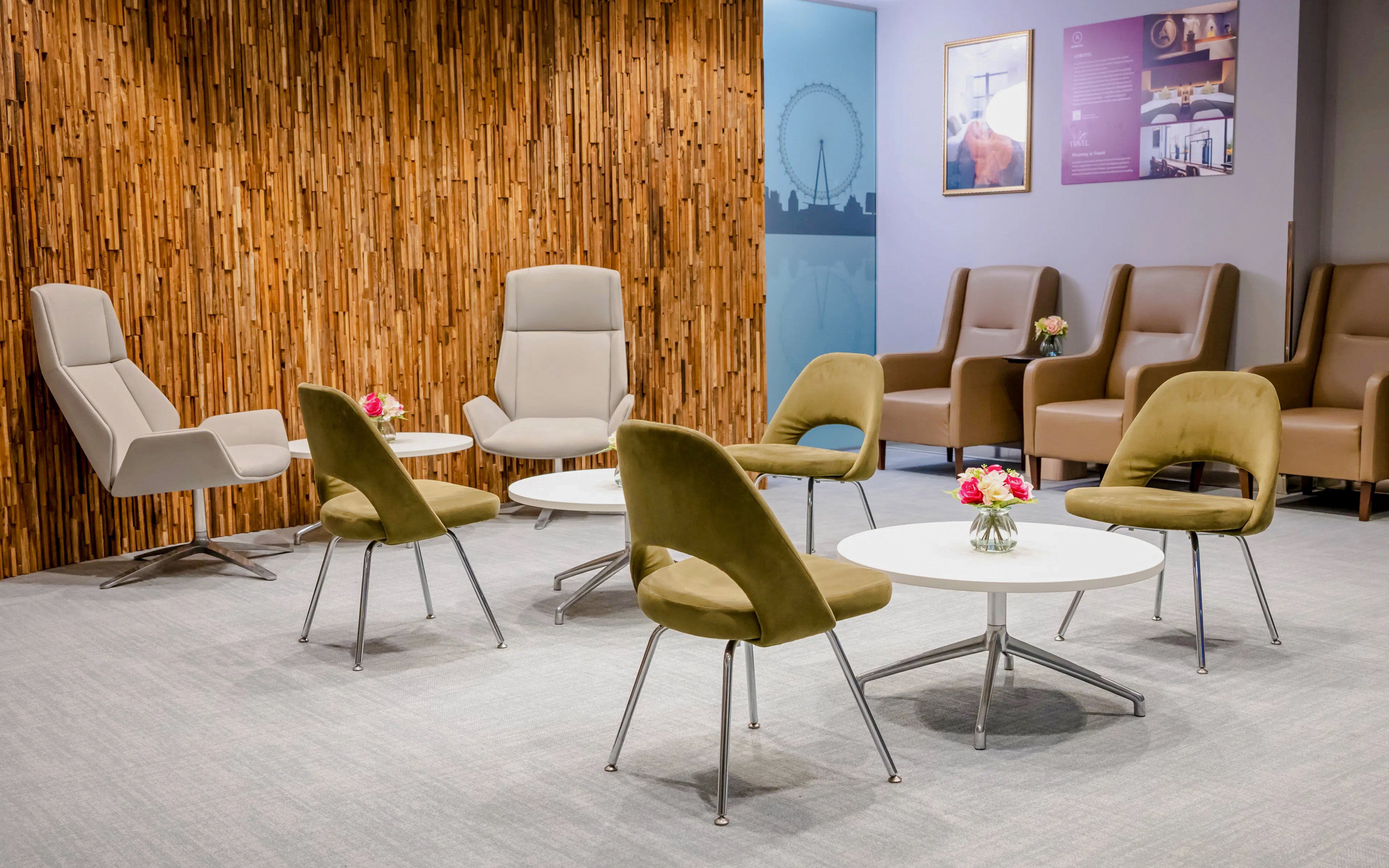 Seating area in Plaza Premium Lounge, London with modern chairs and tables.