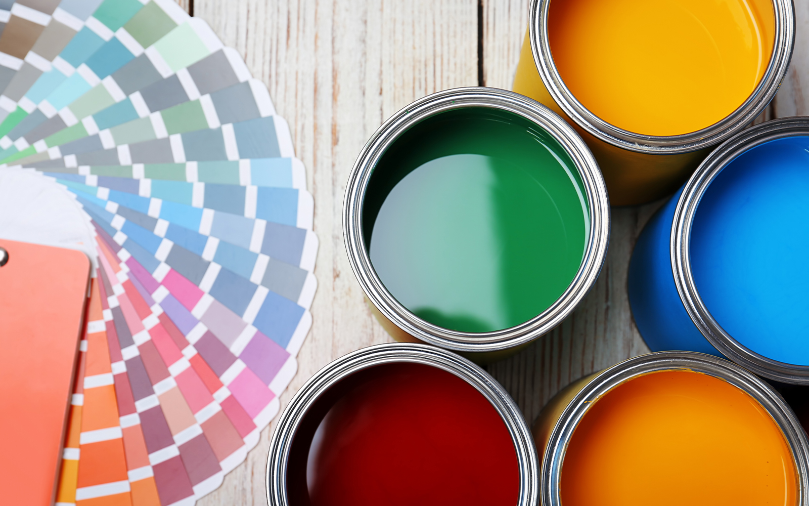 Cans with paint and color palette on wooden background, top view