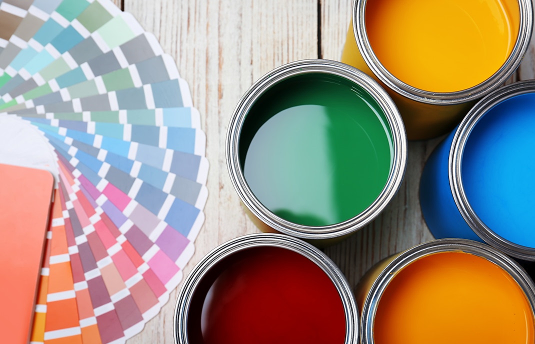 Cans with paint and color palette on wooden background, top view