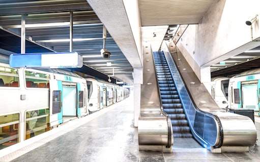 RER train at a Paris station platform with escalator, en route to Disneyland Paris, France.