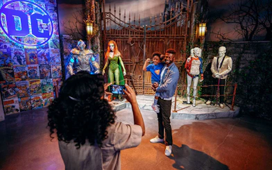 Tourist photographing family near DC exhibit at Warner Bros. Studio.