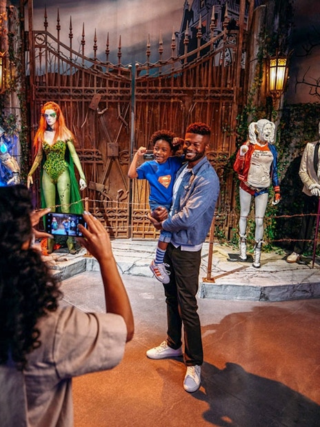 Tourist photographing family near DC exhibit at Warner Bros. Studio.