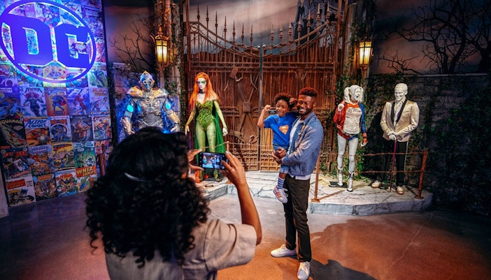 Tourist photographing family near DC exhibit at Warner Bros. Studio.