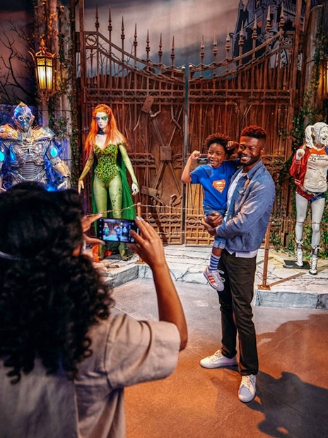 Tourist photographing family near DC exhibit at Warner Bros. Studio.