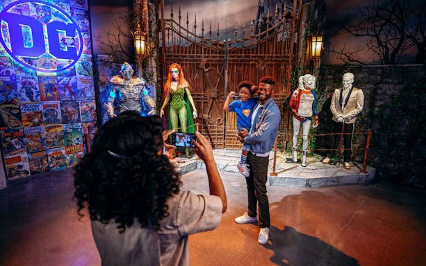Tourist photographing family near DC exhibit at Warner Bros. Studio.