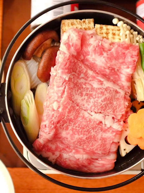 Yakatabune hot pot with beef, vegetables, and mushrooms on a cruise dining table.
