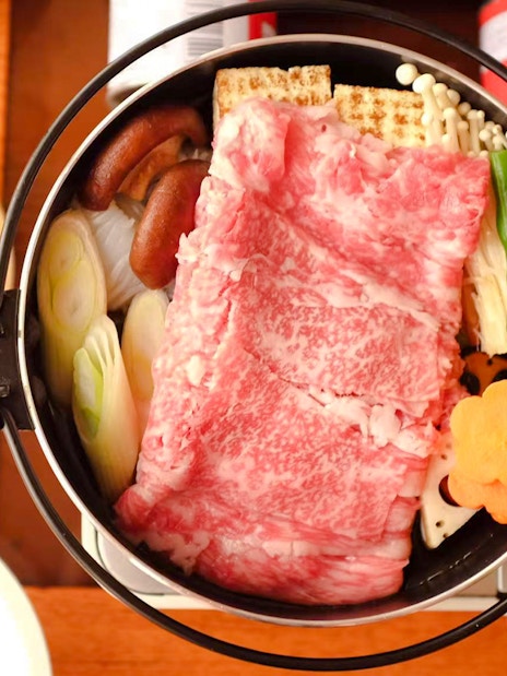 Yakatabune hot pot with beef, vegetables, and mushrooms on a cruise dining table.