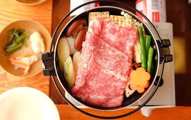 Yakatabune hot pot with beef, vegetables, and mushrooms on a cruise dining table.