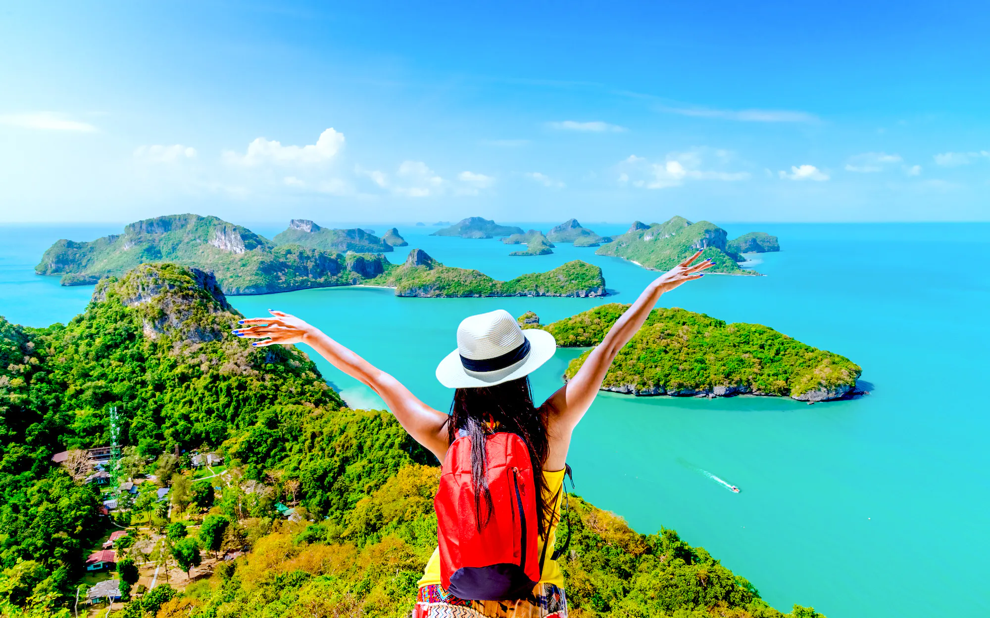 Traveler overlooking Ang Thong Marine Park islands, Koh Samui, with arms raised.