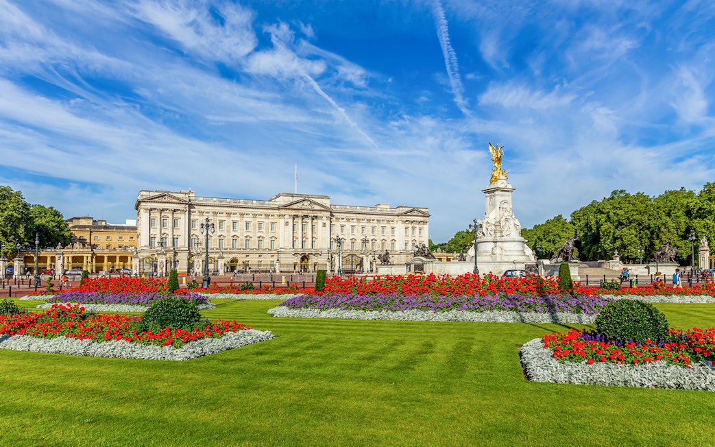 Buckingham Palace with Victoria Memorial and vibrant flower gardens in London.