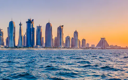 Doha skyline at sunset viewed from the sea during a fishing trip experience.