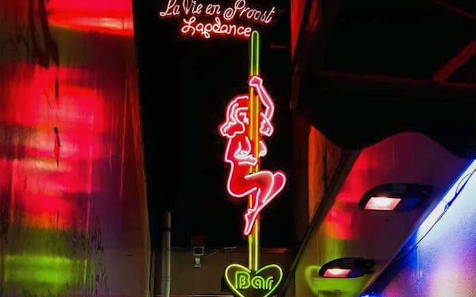 Neon sign in Amsterdam's Red Light District depicting a dancer, part of the Coffeeshop Tour.