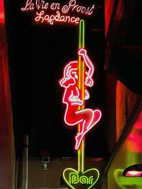 Neon sign in Amsterdam's Red Light District depicting a dancer, part of the Coffeeshop Tour.