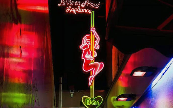 Neon sign in Amsterdam's Red Light District depicting a dancer, part of the Coffeeshop Tour.