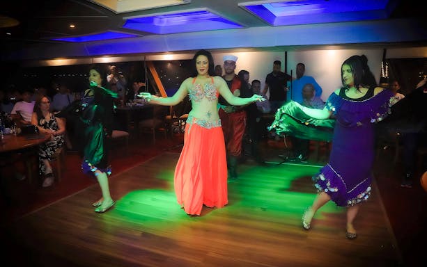 Belly dance performance on 4-Star Nile Dinner Cruise with audience in background.