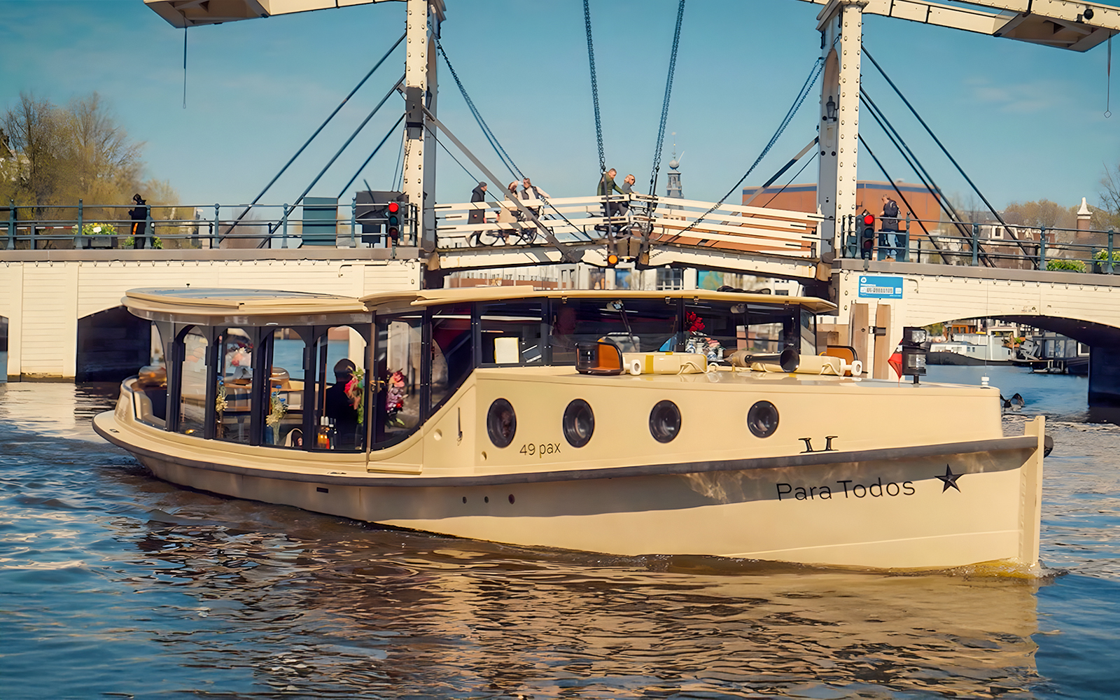 Historic luxury boat on Amsterdam canal near a drawbridge, part of 17th Century VR Cruise.
