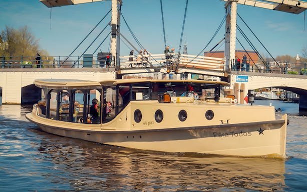 Historic luxury boat on Amsterdam canal near a drawbridge, part of 17th Century VR Cruise.