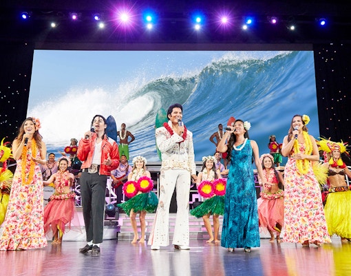 Performers on stage at Rock-A-Hula Show in Honolulu, Hawaii, showcasing vibrant Hawaiian dance and music.