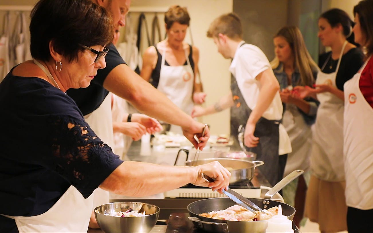 Small group cooking class in Florence preparing dinner together.
