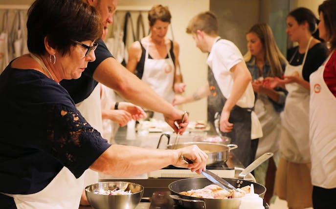 Small group cooking class in Florence preparing dinner together.